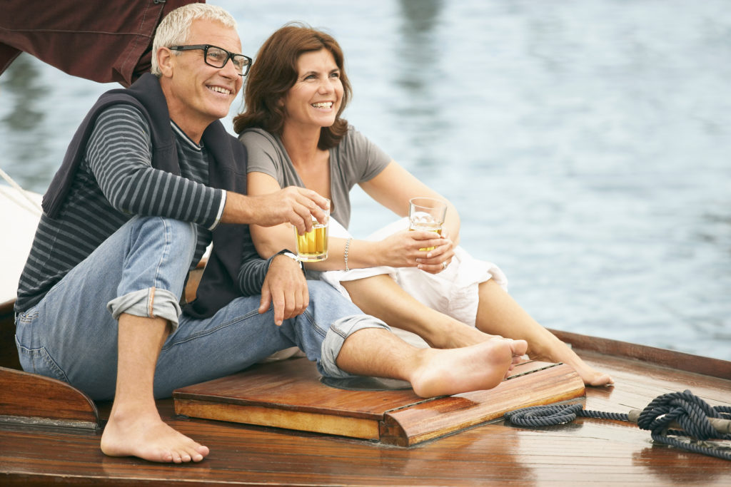 Couple sitting on sailboat | 55 Plus Community in Maine | Active Adult Community
